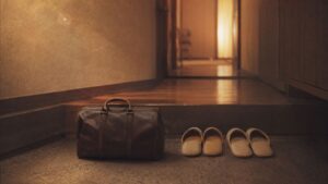 玄関に置かれた旅行かばんと二組のスリッパ