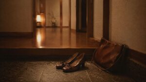 玄関の上がり口に脱ぎ置かれた靴とバッグ
